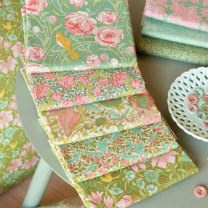 Stack of fabric samples with floral patterns on a chair