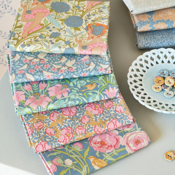 Collection of colorful fabric swatches and buttons on a table with a patterned background.